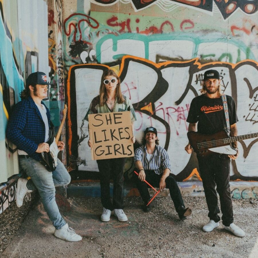four band members from dexter and the moonrocks stand in front of a graffiti wall promoting their upcoming rock show
